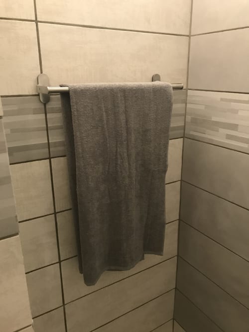 Gray towel hanging on chrome rack in tiled bathroom at Beach House Fos, Fos-sur-Mer