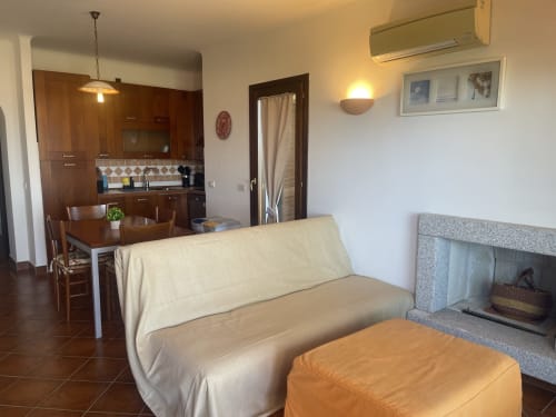 Sea View Garden apartment living area with cream sofa, fireplace, dining table, and modern kitchen at Like at Home Palau,