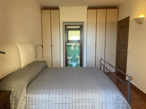Spacious bedroom at Like at Home Palau with queen bed, ensuite bathroom, and sea view in Sardinia
