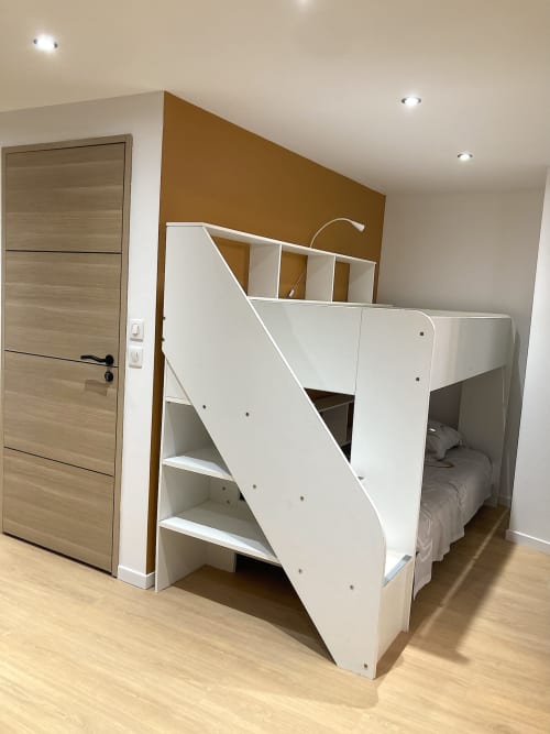 Dormitorio loft moderno con cama litera blanca y almacenamiento integrado en Au Château De Villelongue, Francia