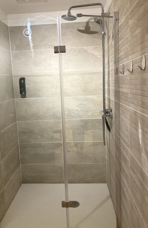 Moderno baño de ducha abierta con alcachofa de lluvia y cristalería en Au Château De Villelongue en Villelongue-d'Aude, Francia