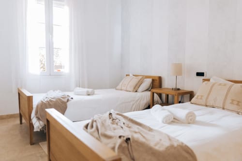 Bright bedroom at Rodas by BH Marbella with twin beds, wooden frames, white linens, and garden view in Marbella