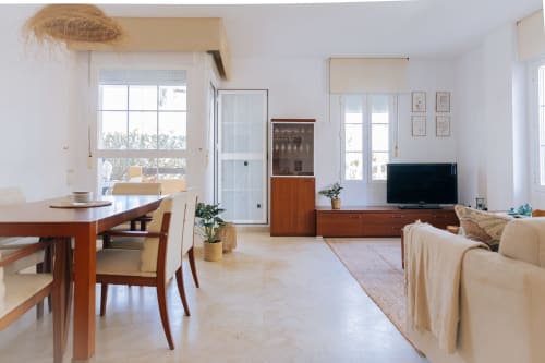 Bright open-plan apartment at Rodas by BH Marbella with dining area, living room with TV, wooden furniture, and garden views