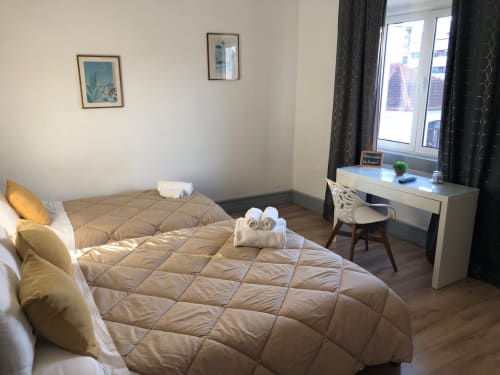 Quarto triplo luminoso na Guest House Infante Dom Henrique em Coimbra com duas camas, secretária e vista para a cidade