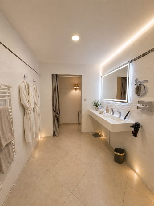 Salle de bain luxueuse à la Chambre La Milande à La Biche Au Bois, Moncléra avec miroir rétroéclairé, plan vasque blanc et chauffant