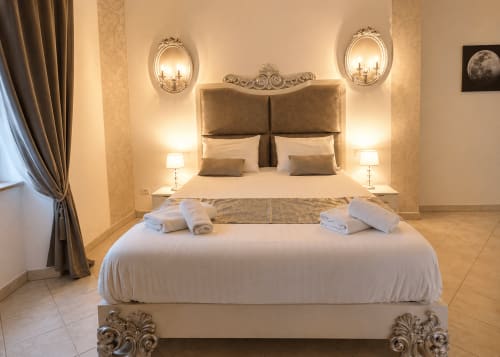 Chambre luxueuse à La Biche Au Bois à Moncléra avec tête de lit ornementée, éclairage élégant et serviettes roulées