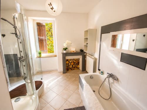 Salle de bain spacieuse du gîte La Biche Au Bois avec douche, baignoire et équipements modernes à Moncléra