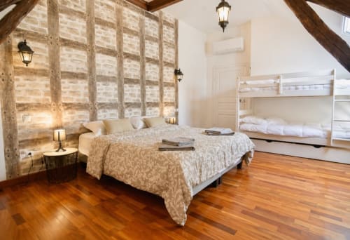 Chambre spacieuse du cottage La Biche Au Bois avec lit queen-size, lits superposés, poutres en bois et parquet