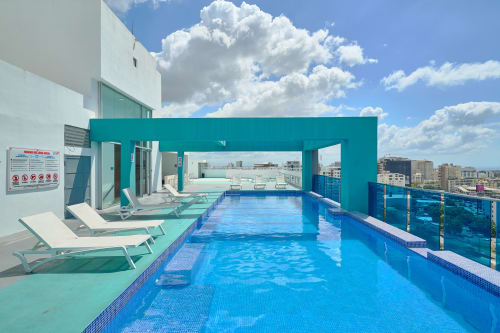 Rooftop pool at Booking RD luxury apartment in Downtown Santo Domingo with city views and lounge chairs