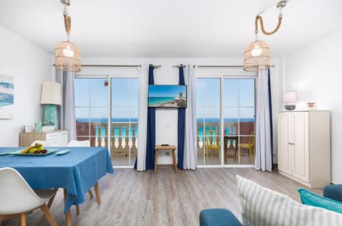 Luminoso apartamento costero en Smart Rent Fuerteventura con vistas al mar turquesa, mobiliario moderno y acceso a balcón
