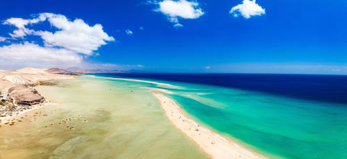 Playa turquesa virgen con arena dorada y aguas cristalinas cerca de Smart Rent Fuerteventura, Islas Canarias