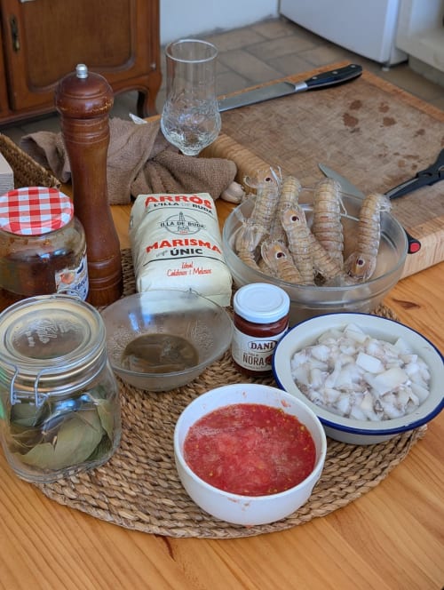 Ingredientes de mariscos españoles en la cocina del hotel Cala Pipa: camarones, pescado blanco, salsa de tomate y productos locales del Delta para