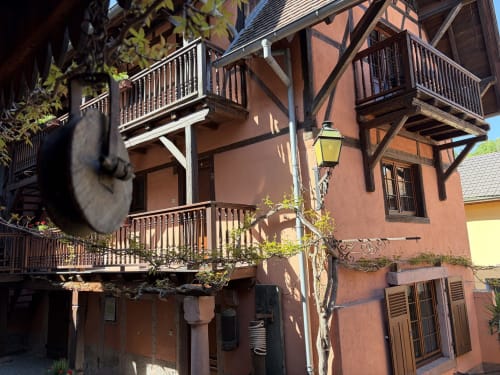 Hôtel de l'Ange à Niedermorschwihr : architecture à colombages de teinte terra cotta avec balcons en bois