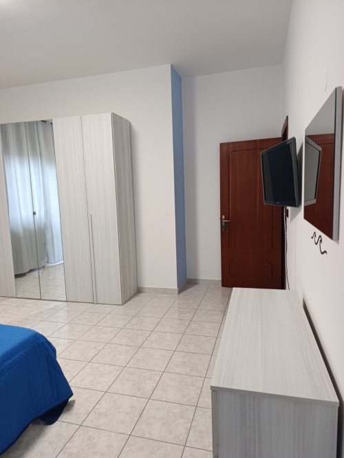 Camera da letto moderna nell'appartamento Tales of Abruzzo Atessa con armadio a specchio, TV a schermo piatto e pavimento in ceramica