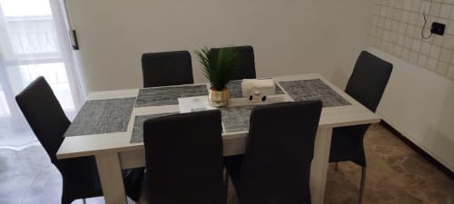 Zona pranzo nell'appartamento DUE ORIZZONTI ad Atessa con tavolo, sedie nere e pianta
