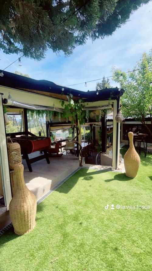 La terrasse de la Villa Tosca à Callian avec pergola, gazon synthétique, décoration en rotin et vues sur les montagnes