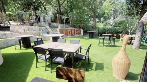La végétation luxuriante du patio-jardin de la Villa Tosca avec tables de salle à manger, sièges et aménagement paysager à Callas, France