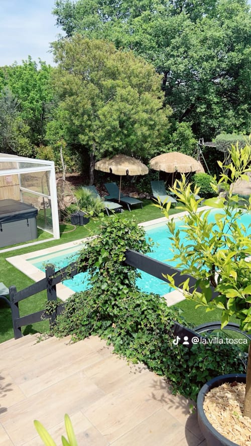 L'espace piscine de la Villa Tosca à Callian avec sa piscine turquoise, transats, parasols et jardins luxuriants