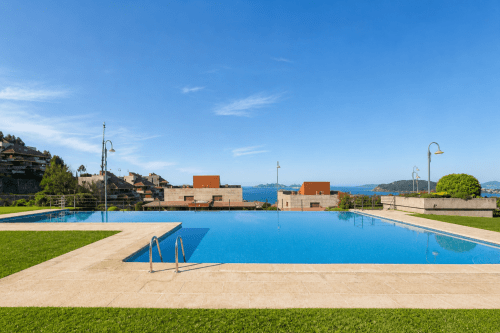Piscina infinity con vistas a la costa de Baiona, apartamento Holibai con vistas al mar y jardines verdes