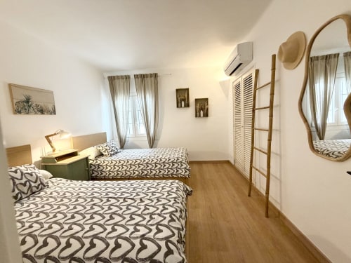 Amplia habitación doble en Villa Alegria B&B en Cala d'Or con ropa de cama estampada y comodidades modernas