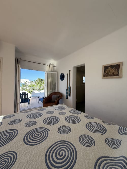 Bright bedroom at Villa Alegria in Cala d'Or with spiral patterned bedding and sea view terrace