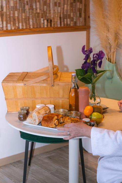 Petit-déjeuner gourmand à la Domaine Langelet avec viennoiseries fraîches, fruits et iris mauves à Saint-Gauzens