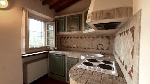 Cucina compatta nell'Appartamento Deluxe a Borgo di Erboli, Cavriglia, con mobili verdi, rivestimento in piastrelle e piano cottura elettrico