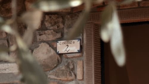 Dettaglio di muro in mattoni a vista presso l'appartamento Borgo di Erboli a Cavriglia con etichetta identificativa della stanza