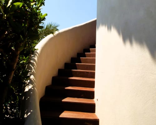 Escalera blanca curva con escalones de terracota en El Origen Villas & Spa, Puerto Escondido, México