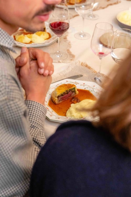 Diners enjoying Anjou cuisine with wine at Moulin de Gaubourg, a French countryside bed and breakfast, featuring beef