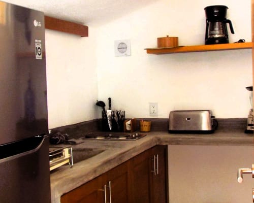 Encimera de cocina con electrodomésticos de acero inoxidable en bungalow de El Origen Villas & Spa, Puerto Escondido