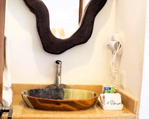 Moderno lavamanos de madera con grifo cromado en el baño de bungalow de El Origen Villas & Spa, Puerto Escondido