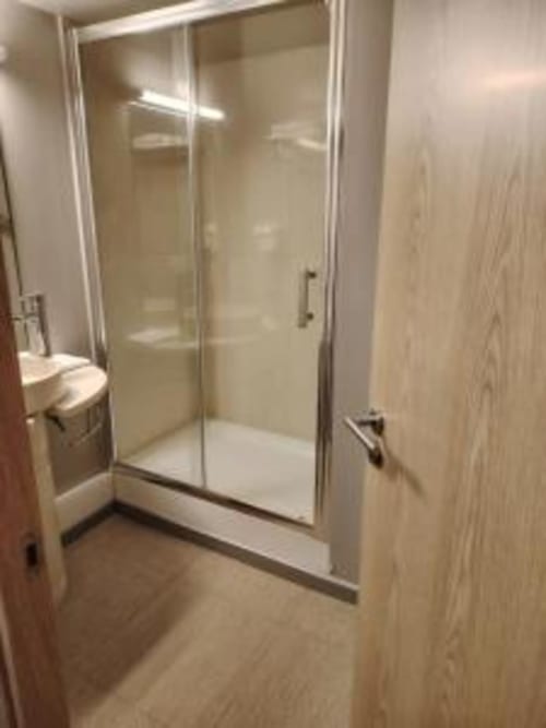 Douche moderne avec portes vitrées dans la salle de bains de l'appartement Les Balcons du Sancy, Picherande