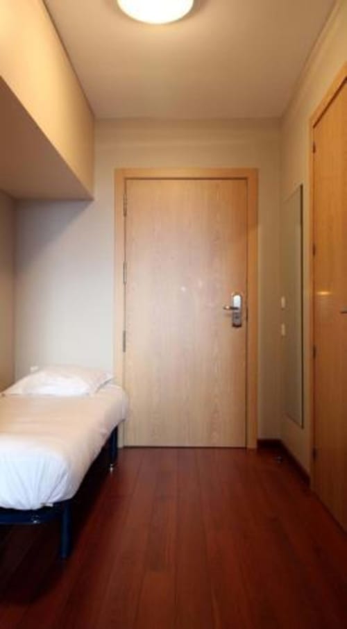 Couloir de la chambre Studio Supérieur aux Balcons du Sancy à Picherande avec lit et portes en bois