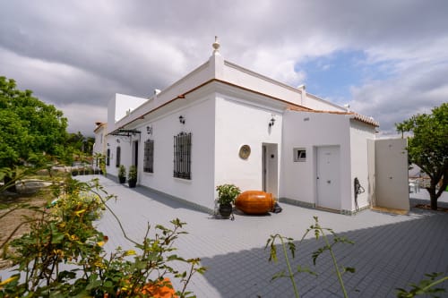 Edificio de hotel estilo mediterráneo blanco con tejado de barro en Hotel Boutique Alcazaba Salobreña, Granada, rodeado de