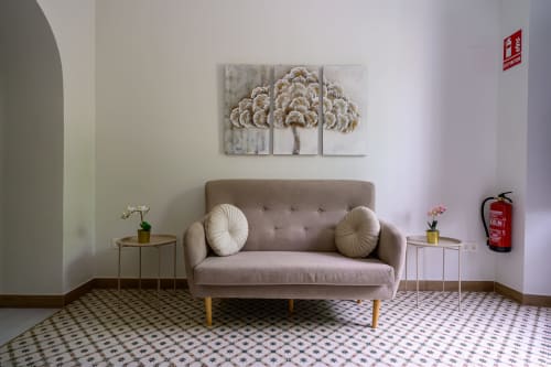 Sala de estar de boutique hotel con sofá beige, obra de arte decorativa de árbol y piso estampado en Salobreña
