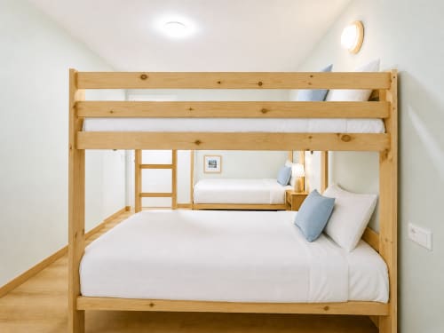 Camas litera de madera con sábanas blancas en el dormitorio luminoso de Holibai, Baiona