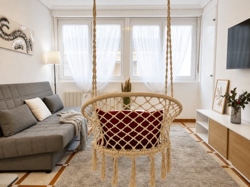 Luminoso apartamento en Baiona con silla colgante de macramé, sofá gris y vistas al mar en Holibai Mencer