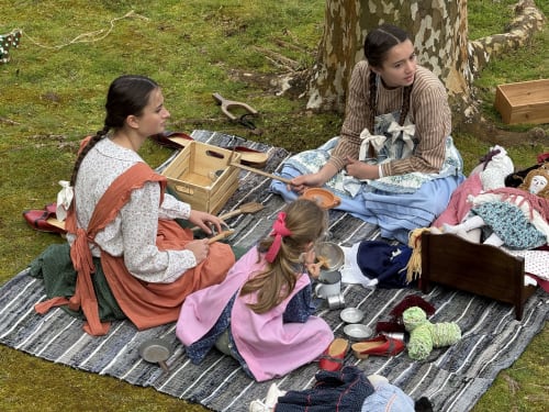 Three people enjoying outdoor picnic with period costumes and vintage items at Golden Mermaid Villa, Ribeirinha Portugal