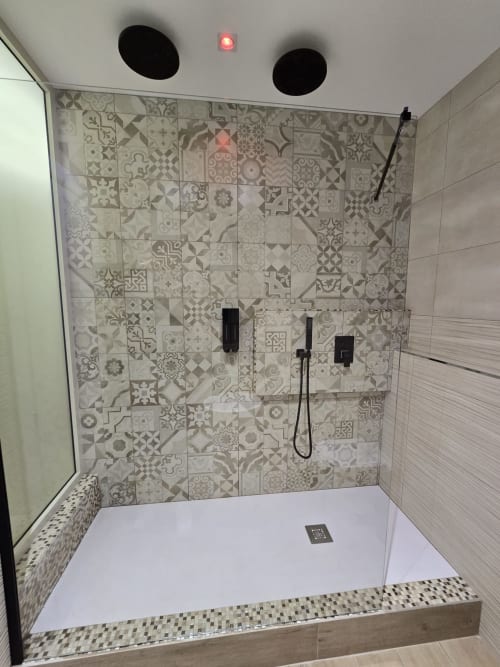 Moderna cabina doccia con piastrelle decorate e soffione pioggia presso Elite Apartment SPA a Catania