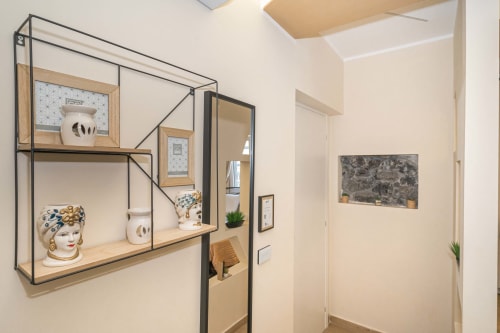 Bagno moderno con scaffale a parete che espone ceramiche decorative nell'Elite Apartment SPA, Catania