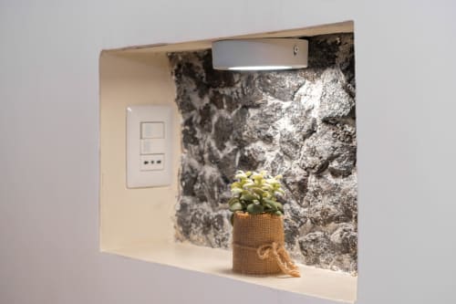 Dettaglio bagno Camera Queen presso Elite Apartment SPA Catania con parete in pietra e pianta in vaso