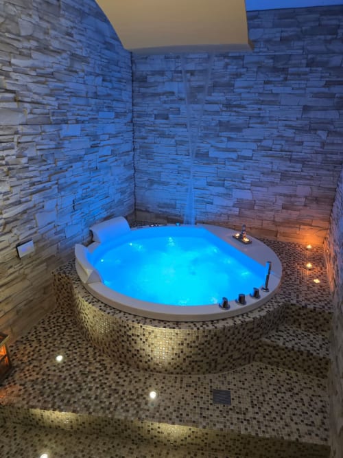 Vasca idromassaggio lussuosa illuminata con luci blu nella spa dell'Elite Apartment SPA, Catania