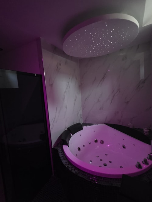 Lussuosa vasca idromassaggio con soffione doccia a pioggia illuminato presso Elite Apartment SPA, Catania