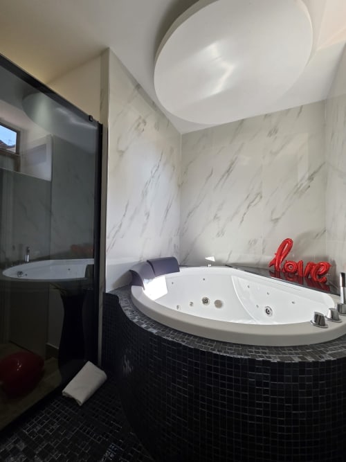 Bagno della lussuosa King Suite presso Elite Apartment SPA Catania con pareti in marmo, vasca jacuzzi e comfort moderni