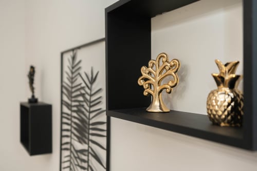 Albero decorativo dorato e ananas su mensola nera nell'Elite Apartment SPA, Catania
