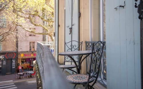 Wrought iron balcony seating with city view overlooking Millau street in Le Central apartment