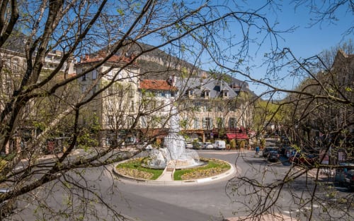 Millau city center square with historic buildings, bare trees, and fountain plaza - Le Central apartment location