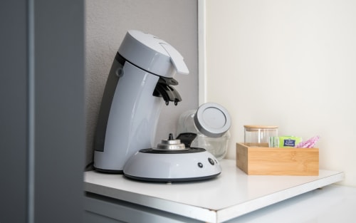 Nespresso coffee maker on white desk in La Conciergerie apartment, Millau with office organizer