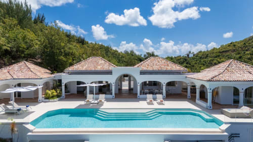 Piscine du resort de luxe Villa Agama à Saint-Martin, toits en terre cuite, architecture voûtée et environnement tropical luxuriant